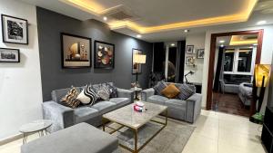 un soggiorno con un divano e un tavolo di Gold Crest Signature One Bedroom Family Apartments - City View DHA Lahore a Lahore