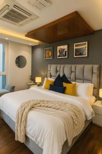 um quarto com uma cama grande com almofadas amarelas e azuis em Gold Crest Signature One Bedroom Family Apartments - City View DHA Lahore em Lahore