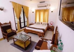 ein Schlafzimmer mit einem Bett, einem Tisch und Stühlen in der Unterkunft The Boho Stays Kochi in Kochi