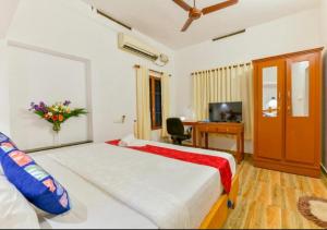 Un dormitorio con una cama y un escritorio con una computadora. en The Boho Stays Kochi, en Kochi