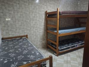 Casa na Praia في برايا جراندي: غرفة بسريرين بطابقين وسرير