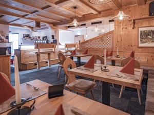 a restaurant with wooden walls and tables and chairs at APART Naturcamping Kuprian in Längenfeld