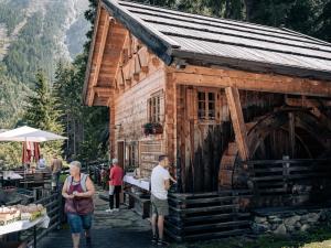 a group of people standing outside of a wooden building at APART Naturcamping Kuprian in Längenfeld