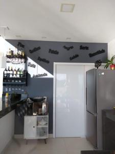a kitchen with a counter and a refrigerator at Casa de Alto Padrão Piscina e Linda Vista para o Mar in Caraguatatuba