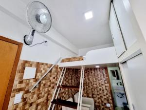 um quarto com uma escada com ventilador em Kitnet Minimalista Mezanino em São Paulo