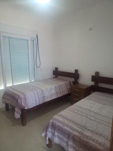 a bedroom with two beds and a window at Casa de Alto Padrão Piscina e Linda Vista para o Mar in Caraguatatuba +11 photos