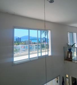 a bathroom with a window with a view of a city at Casa de Alto Padrão Piscina e Linda Vista para o Mar in Caraguatatuba