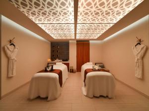 a spa room with four massage beds in a room at Alwadi Hotel Doha - MGallery Collection in Doha