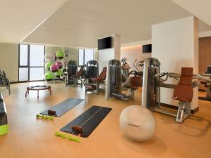 a gym with treadmills and exercise equipment on the floor at Alwadi Hotel Doha - MGallery Collection in Doha