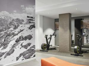 a gym with two exercise bikes and a mountain mural at Pullman Adelaide in Adelaide