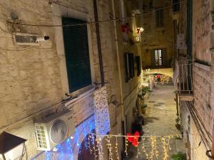 een steegje met kerstverlichting aan de zijkant van een gebouw bij DaDa' Home in Trani +7 foto's