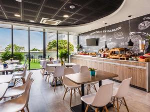 a restaurant with tables and chairs and a counter at ibis Barranquilla in Barranquilla