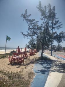 Un grupo de mesas y sillas en la playa. en Casa com 03 Quartos, Piscina e Churrasqueira em Itaipuaçu Maricá RJ, en Maricá