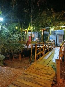 una passerella di legno che conduce a un ristorante di notte di Refúgio Sereno a Bonito