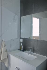 Un baño blanco con lavabo y espejo. en Apartamento Laranjeiras dois, en Bicas 25 fotos más