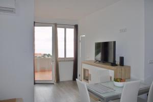 a living room with a table and a television at Apartamento Laranjeiras dois in Palhota
