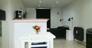 Disfruta Mucho !!! في إل كالافاتي: غرفة معيشة مع طاولة بيضاء عليها زهور