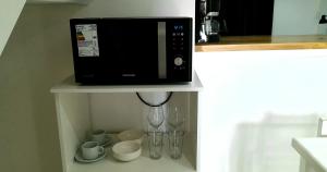 Disfruta Mucho !!! في إل كالافاتي: ميكروويف على رف مع أكواب وكؤوس نبيذ +3 صور