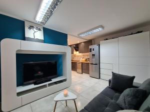 a living room with a couch and a tv at Studio pod Śnieżnymi Kotłami in Piechowice