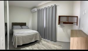 ein Schlafzimmer mit Bett und Vorhängen in einem Zimmer in der Unterkunft Pousada Aloha Pinheira in Palhoça + 9 Fotos