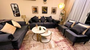 un soggiorno con divani e un tavolo di Gold Crest Signature One Bedroom Family Apartments - City View DHA Lahore a Lahore Altre 120 foto