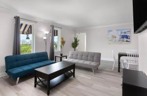 a living room with a blue couch and a table at Ocean Escape Boardwalk Oceanfront in Myrtle Beach