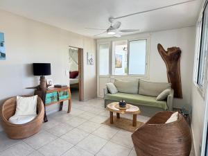 a living room with a couch and a table at Tibo bas de villa NEUF accès 4 plages in Deshaies