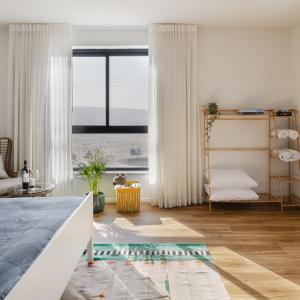 a bedroom with a bed and a large window at Sun Circle - וילה יוקרתית עם בריכה מול הכנרת in Poriyya +30 photos