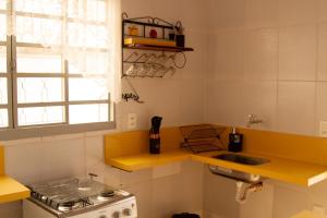 una piccola cucina con lavello e fornello di Casinha Vale do Sol a Nova Lima