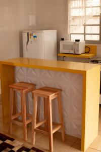 una cucina con un bancone e due sgabelli di Casinha Vale do Sol a Nova Lima