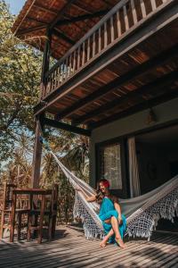 a woman sitting in a hammock on a porch at Pousada Fortal Jeri in Jericoacoara +18 photos