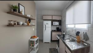 eine Küche mit einem weißen Kühlschrank und einer Spüle in der Unterkunft Pousada Aloha Pinheira in Palhoça