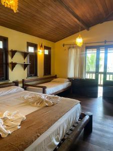 a bedroom with two beds in a room with windows at Vila Bela Vista in Jijoca de Jericoacoara +131 photos
