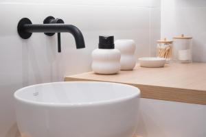 a bathroom with a white sink and a black faucet at You and the view in Mytilene +10 photos
