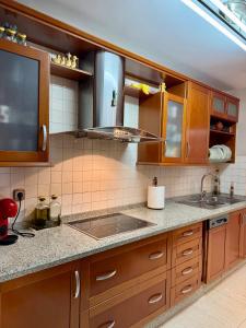 eine Küche mit Holzschränken und einer Spüle in der Unterkunft Grand Beachfront Apartament - Cadiz in Cádiz