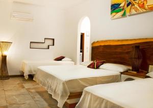 a room with three beds in a room at Hotel Dos Mundos Monterrico - Pacific Resort in Taxisco