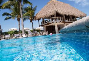 a swimming pool with a house with a resort at Hotel Dos Mundos Monterrico - Pacific Resort in Taxisco