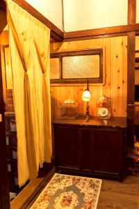 a room with a table with a lamp and a window at 隠れ古宿 おくゆかし in Beppu