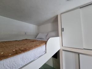 uma cama num pequeno quarto com uma janela em Kitnet Minimalista Mezanino em São Paulo