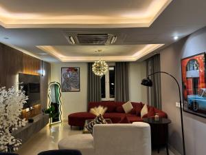 uma sala de estar com um sofá vermelho e uma mesa em Gold Crest Signature One Bedroom Family Apartments - City View DHA Lahore em Lahore