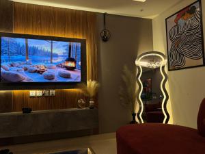uma sala de estar com uma TV de tela plana na parede em Gold Crest Signature One Bedroom Family Apartments - City View DHA Lahore em Lahore