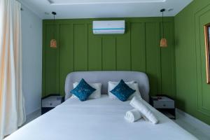 um quarto com uma cama branca e paredes verdes em Gold Crest Signature One Bedroom Family Apartments - City View DHA Lahore em Lahore