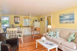 een woonkamer met een bank en een tafel bij Cottage w Private Association Pool in Wellfleet