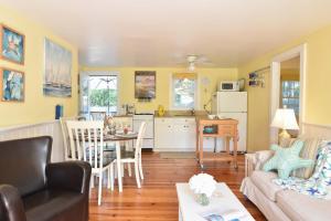 een woonkamer en keuken met gele muren bij Cottage w Private Association Pool in Wellfleet