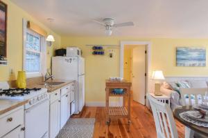 a kitchen with white cabinets and a white refrigerator at Cottage w Private Association Pool in Wellfleet