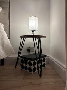 a table with a lamp on top of a box at Cosy- Casa in Luton +4 photos