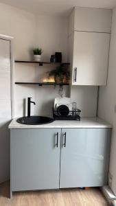 a kitchen with white cabinets and a sink at Cosy- Casa in Luton