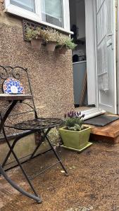 a chair and a table in front of a door at Cosy- Casa in Luton