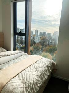een slaapkamer met een bed en een groot raam bij Boutique New 1-Bedroom Condo in Heart of Downtown in Vancouver +9 foto's