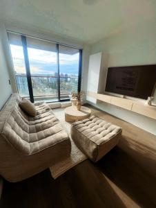 een woonkamer met een bed en een groot raam bij Boutique New 1-Bedroom Condo in Heart of Downtown in Vancouver